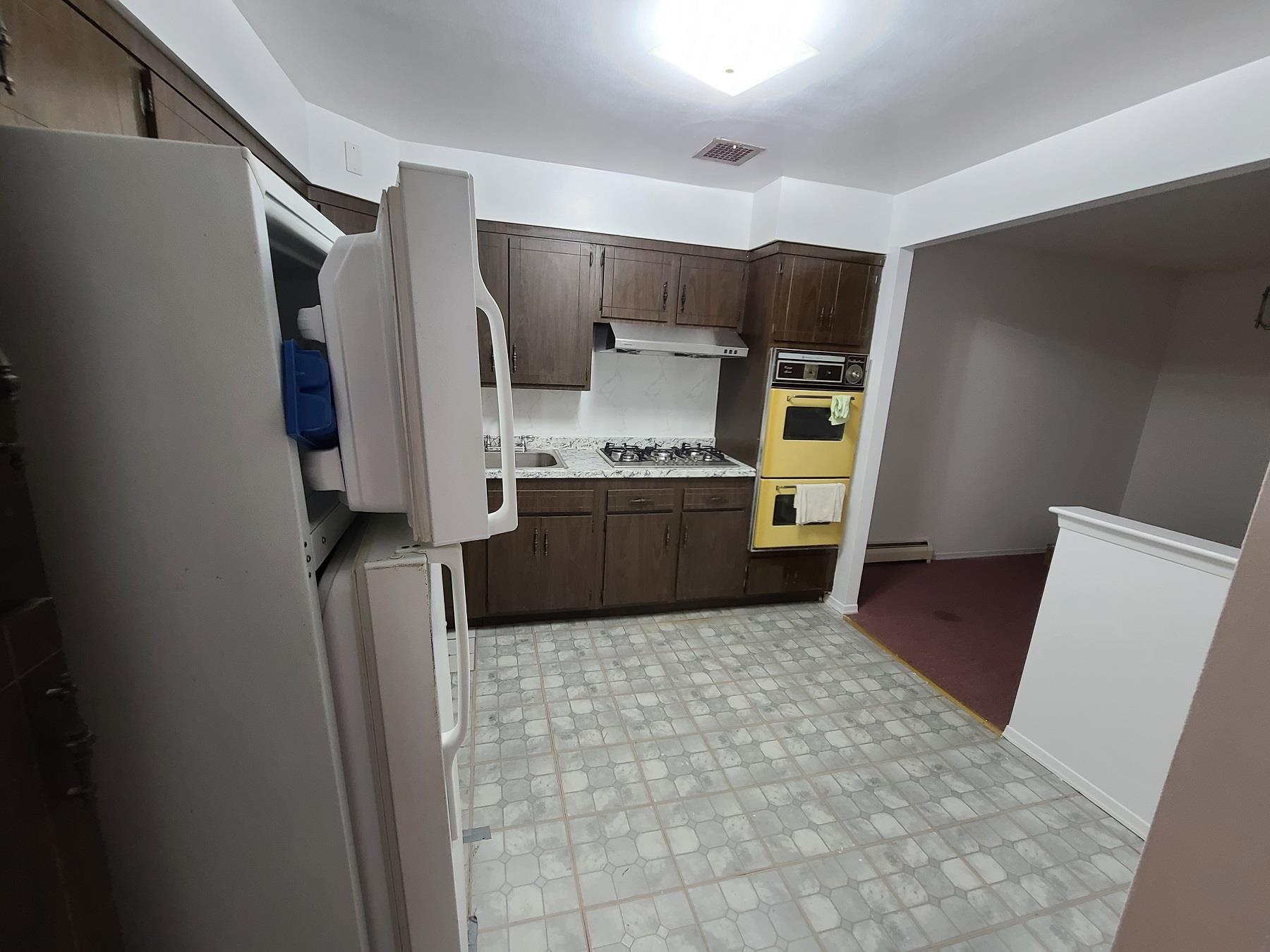 85-10 165th Street Queens, NY 11432 - Photo 15 of 24 a kitchen with stainless steel appliances a refrigerator and a sink