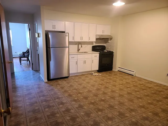 a kitchen with a refrigerator and a stove top oven