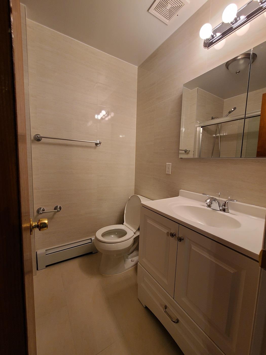 85-10 165th Street Queens, NY 11432 - Photo 9 of 24 a bathroom with a toilet sink and mirror