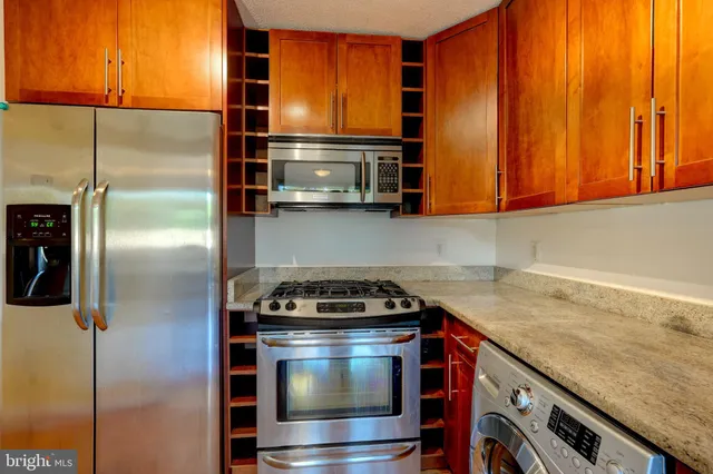 a kitchen with appliances a sink and cabinets