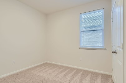 709 Iron Brg Road Georgetown, TX 78626 - Photo 10 of 11 A well-lit bedroom features plush carpeting and window blinds, ready for personalization.