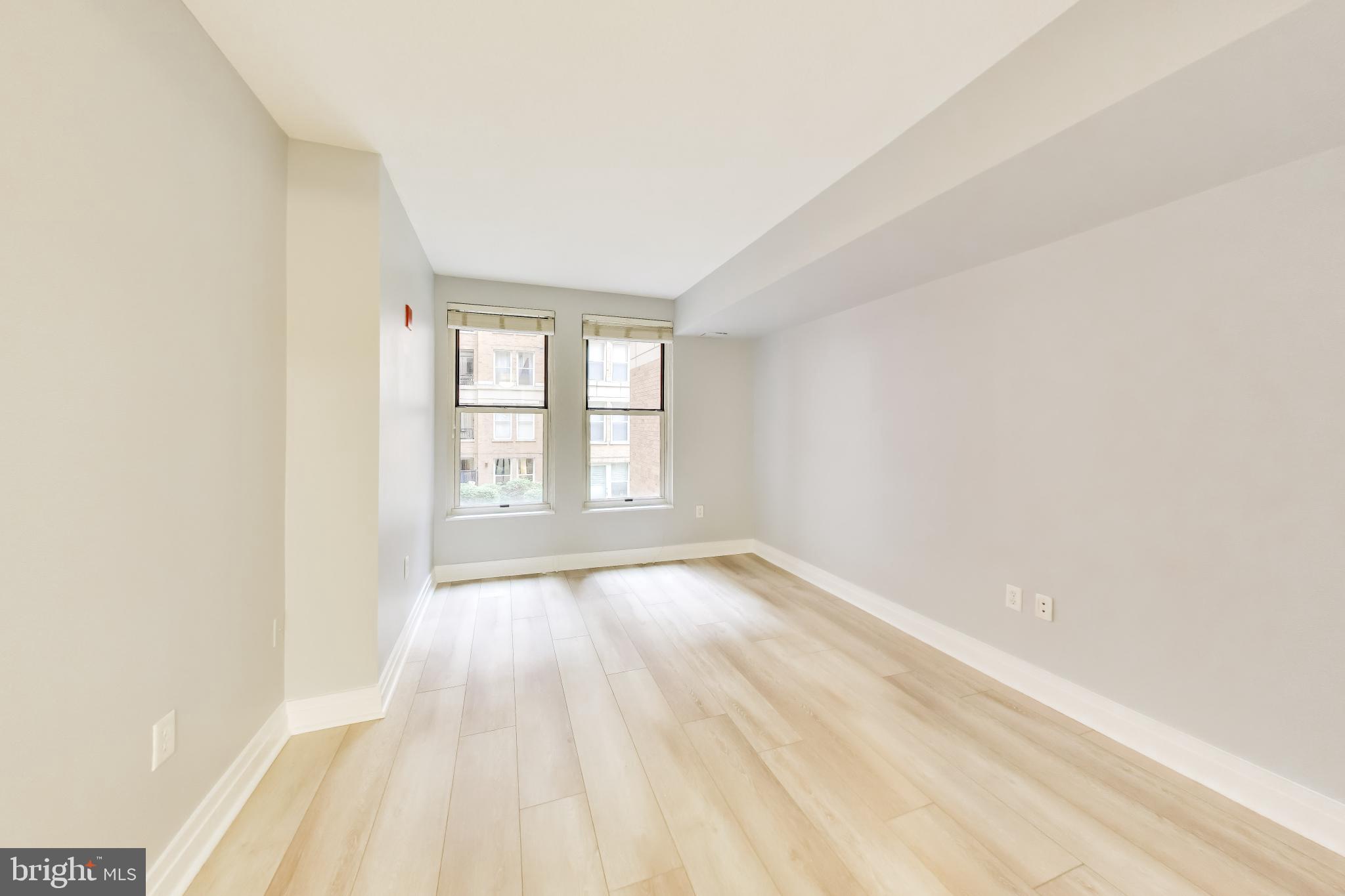 915 E Street Northwest, Unit 414 Washington, DC 20004 - Photo 13 of 35 an empty room with wooden floor and windows