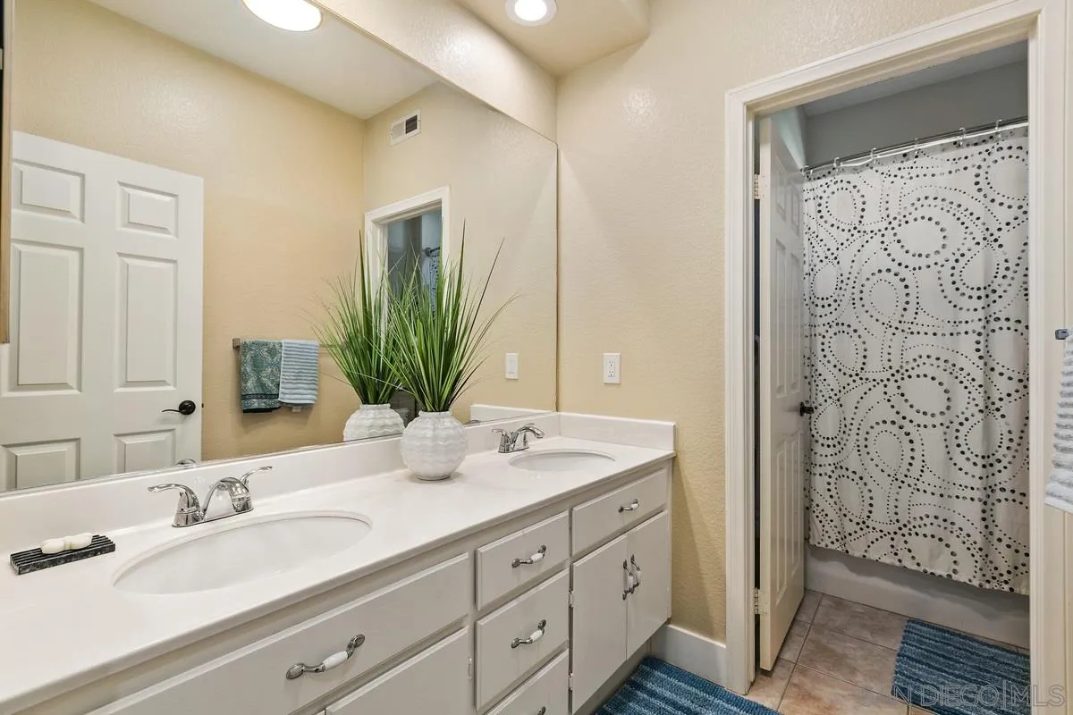 1461 Knoll Park Glen Escondido, CA 92029 - Photo 19 of 25 a bathroom with double vanity sinks a mirror and a shower