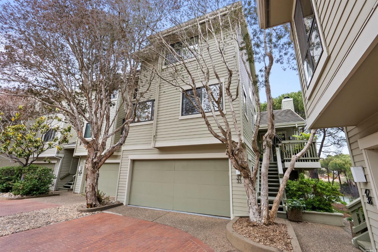 a front view of a house with a tree