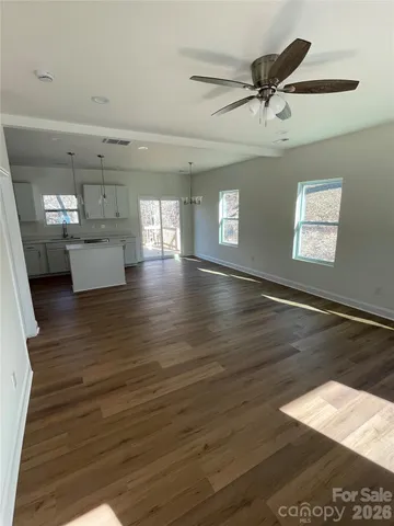 a view of a big room with wooden floor and windows