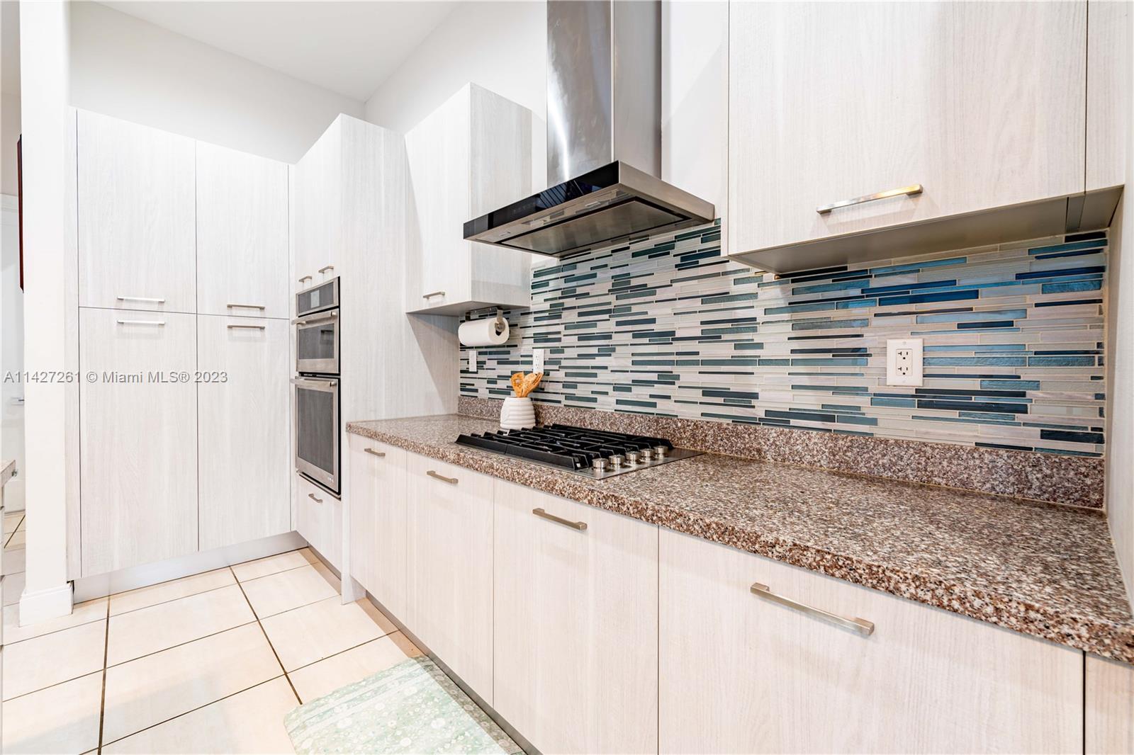 8210 Northwest 46th Street Doral, FL 33166 - Photo 21 of 59 a kitchen with granite countertop a sink and a stove