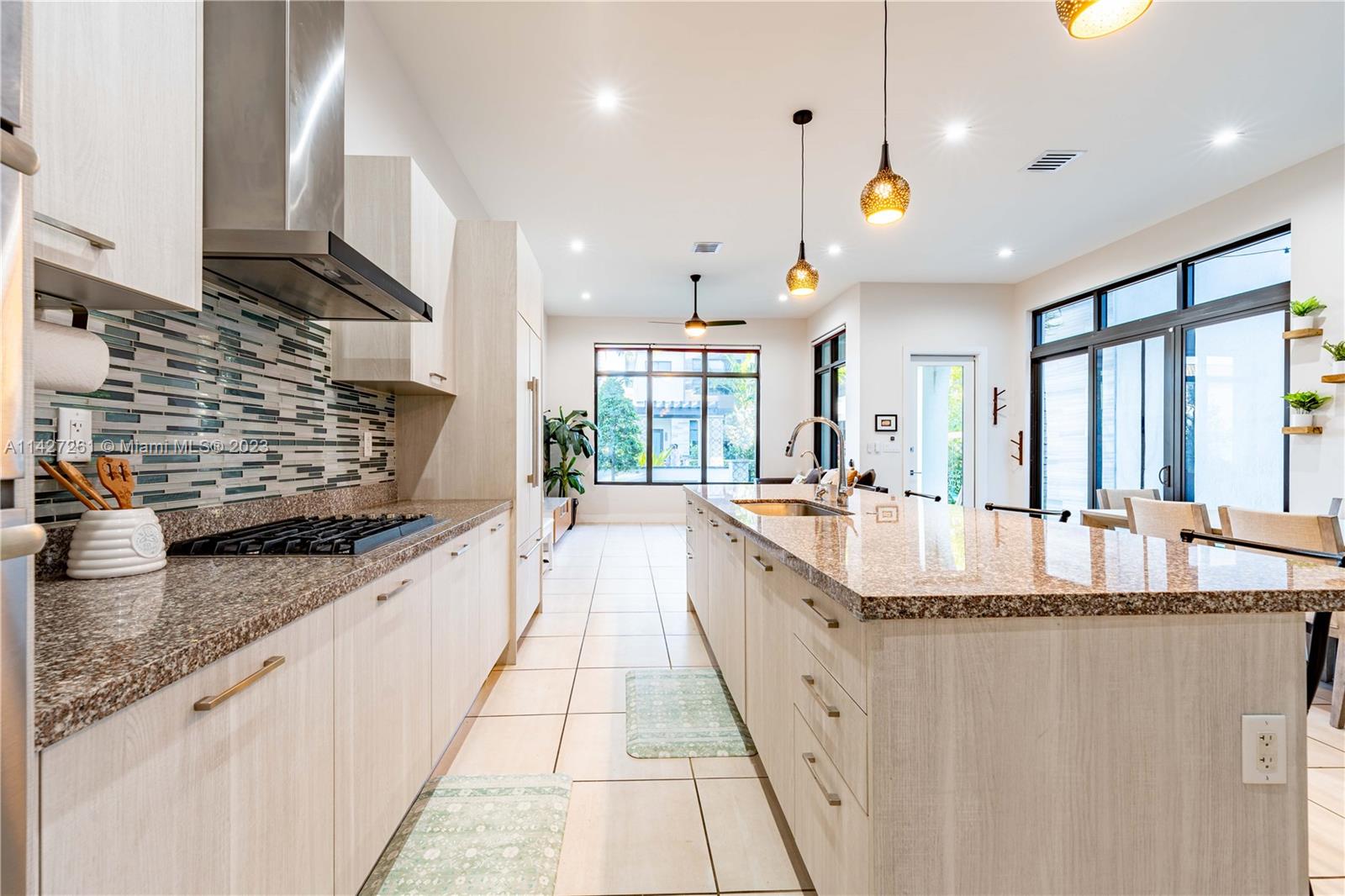 8210 Northwest 46th Street Doral, FL 33166 - Photo 23 of 59 a large kitchen with kitchen island granite countertop a large counter top stainless steel appliances and a sink