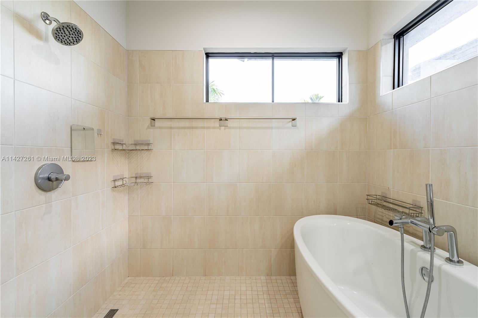 8210 Northwest 46th Street Doral, FL 33166 - Photo 32 of 59 a bathroom with a tub a window and a shower