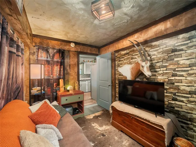 a living room with furniture a flat screen tv and a floor to ceiling window