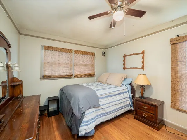 a bedroom with a bed chandelier and a window