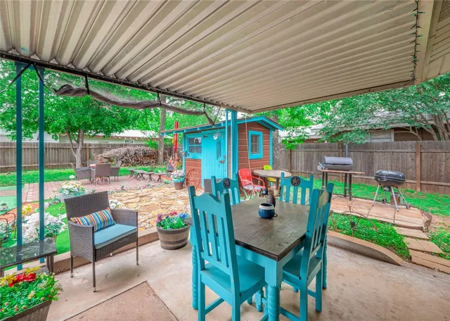 a view of a patio with a table chairs and a backyard