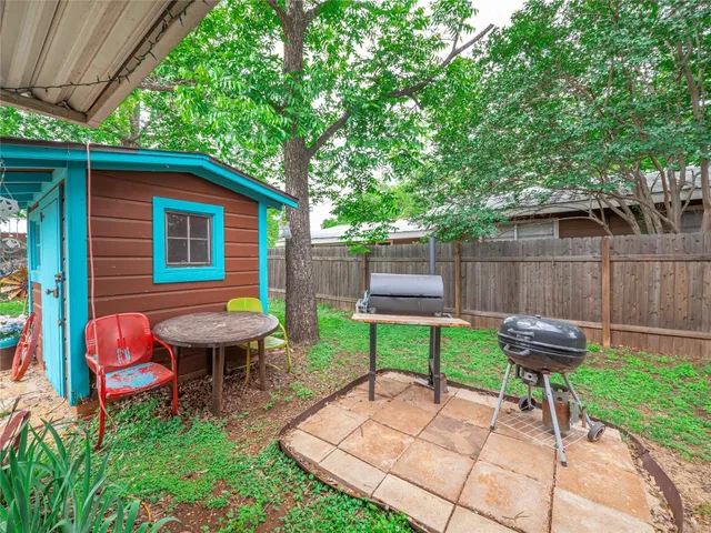 a backyard of a house with table and chairs