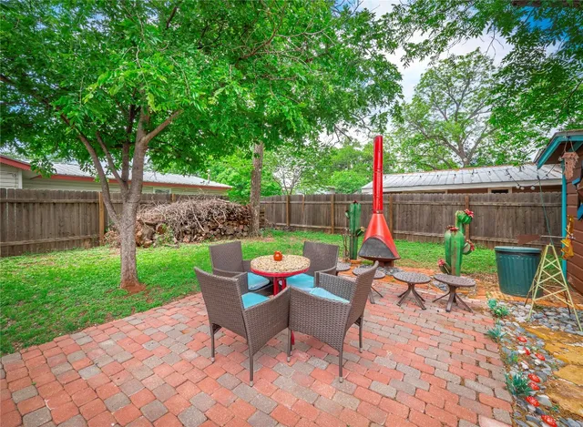 a view of backyard with seating space and trees