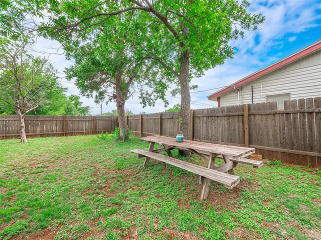 a backyard of a house with table and chairs