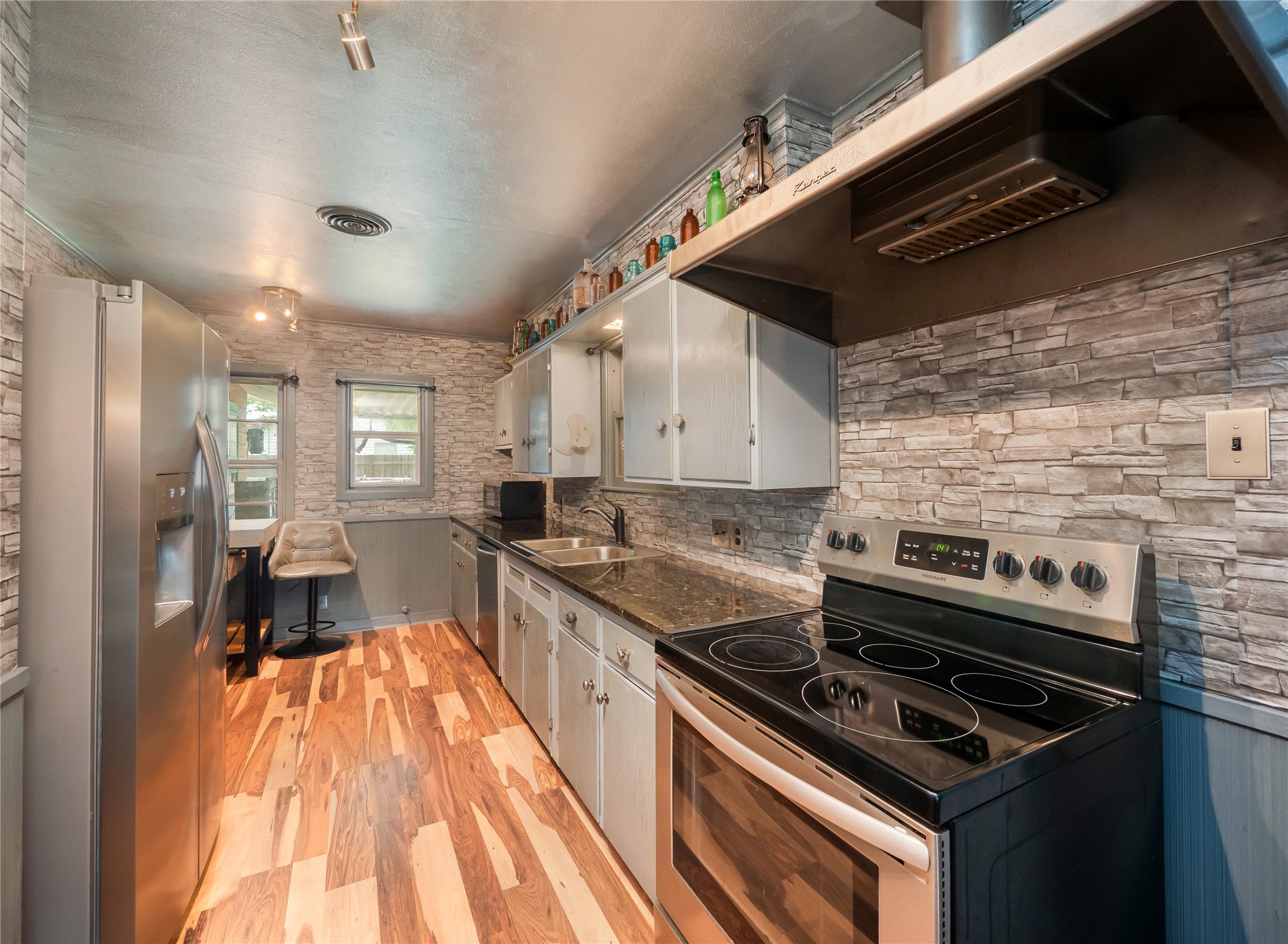 1207 Flag Street Llano, TX 78643 - Photo 4 of 40 a kitchen with a stove and a wooden floor
