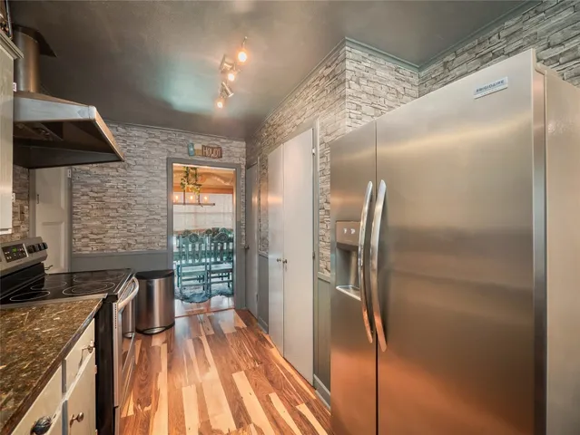 a kitchen with stainless steel appliances granite countertop a refrigerator and a sink