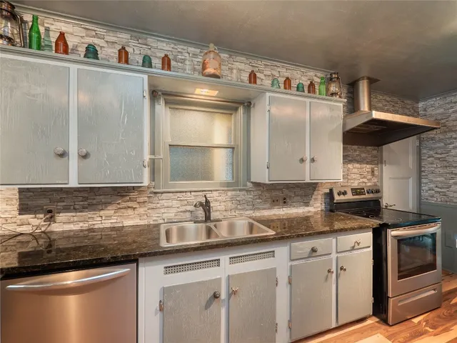 a kitchen with stainless steel appliances granite countertop a sink and cabinets