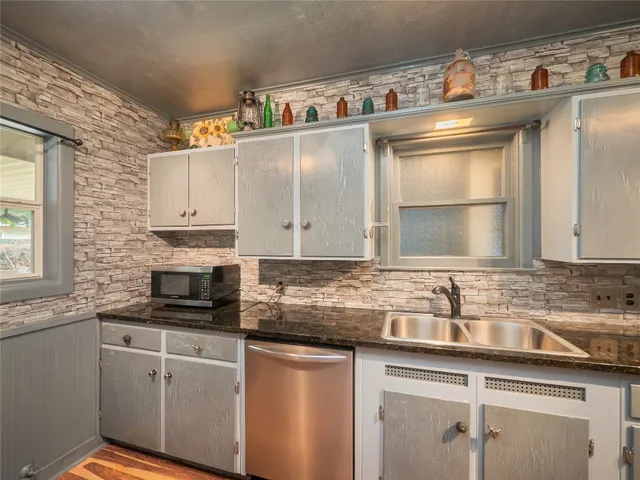 a kitchen with stainless steel appliances granite countertop a sink stove and cabinets
