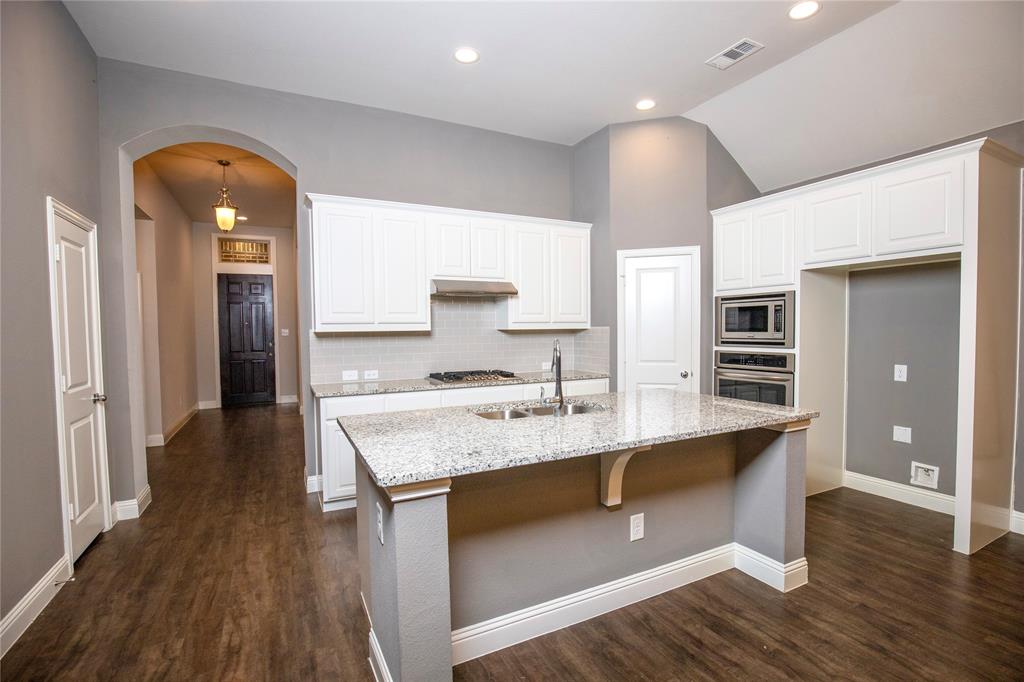 987 Canterbury Lane Forney, TX 75126 - Photo 3 of 22 a large kitchen with stainless steel appliances granite countertop a lot of counter space and wooden floors