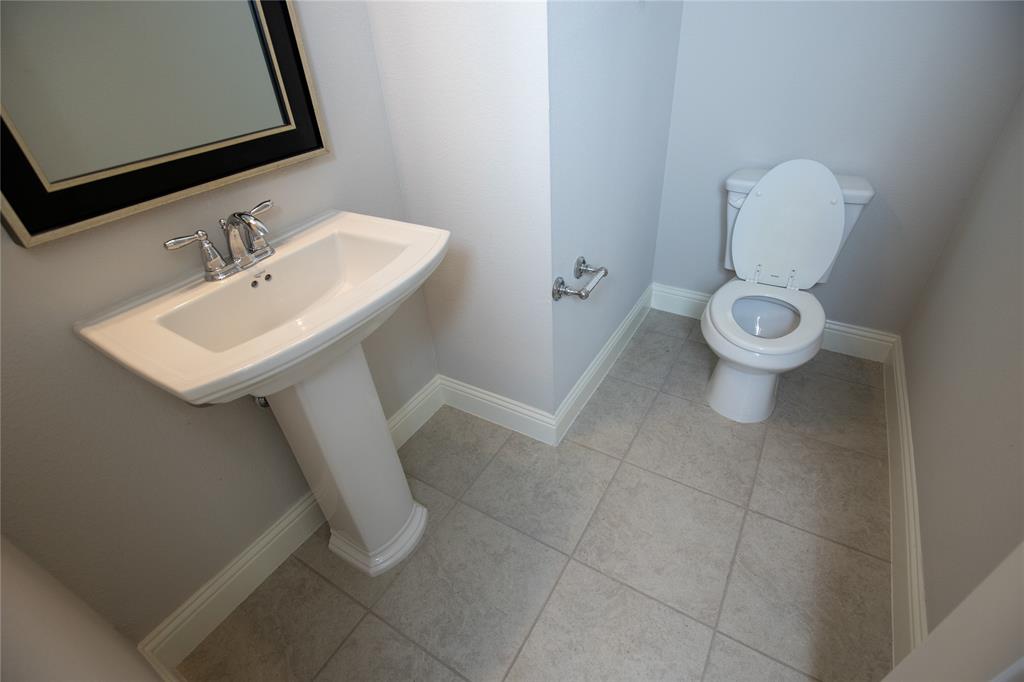 987 Canterbury Lane Forney, TX 75126 - Photo 10 of 22 a white toilet sitting next to a bathroom sink