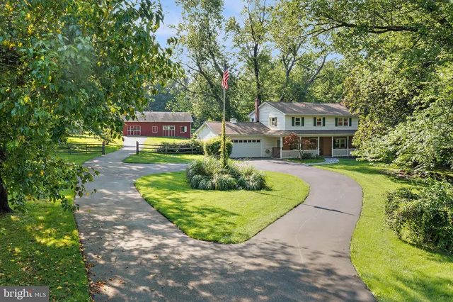 a front view of a house with a garden and trees
