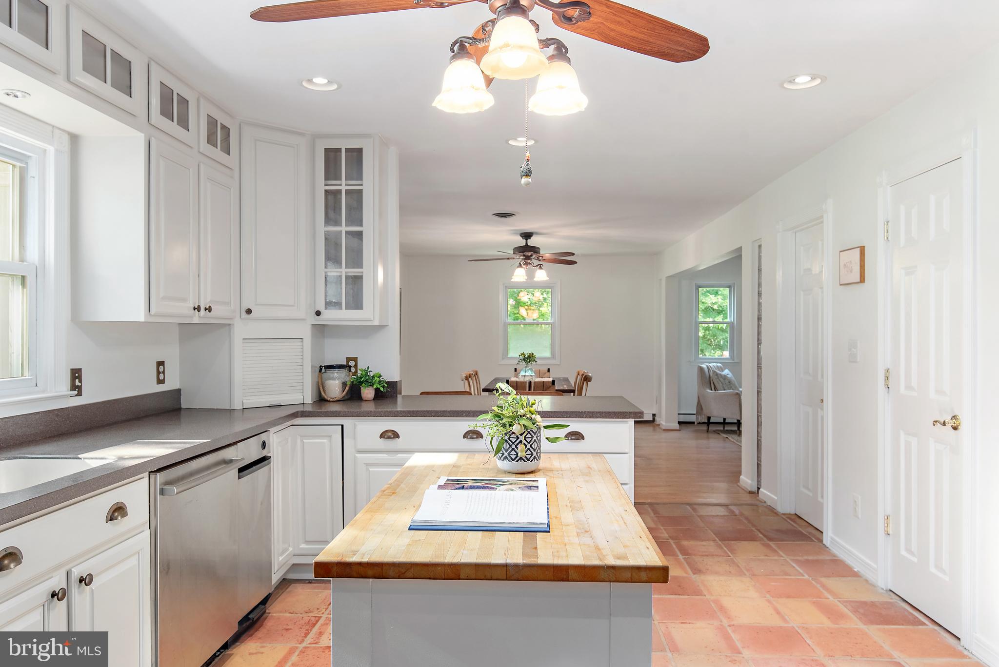 3514 Williamsburg Road Davidsonville, MD 21035 - Photo 3 of 50 a large white kitchen with kitchen island granite countertop wooden cabinets a granite counter top and a fireplace
