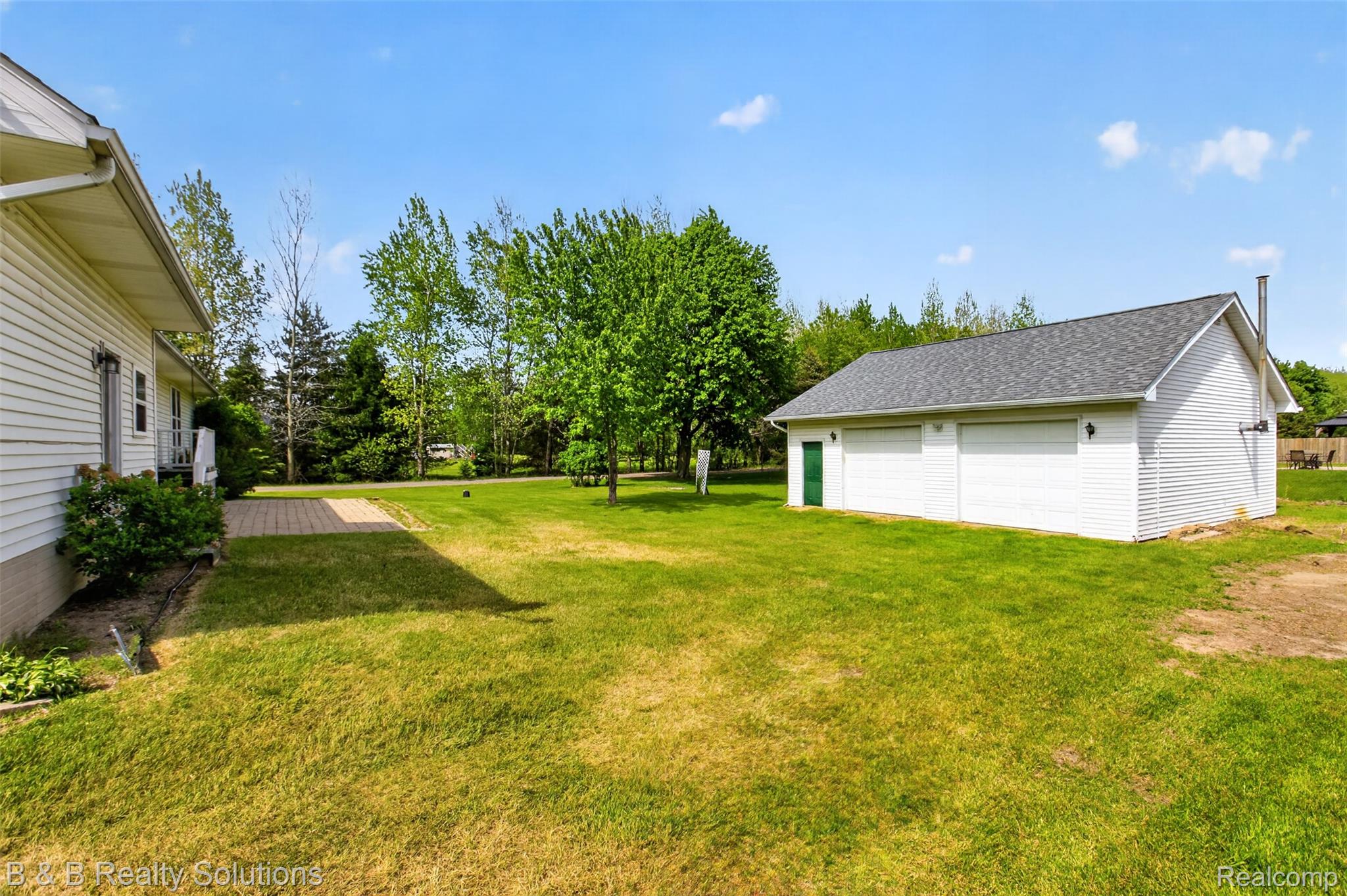 6100 Fish Lake Road North Branch, MI 48461 - Photo 3 of 45 View of green lawn with a garage and an outdoor structure