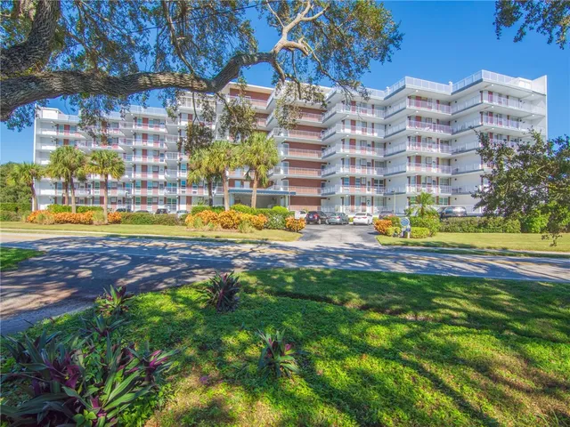 a view of pool with lawn chairs and flower plants