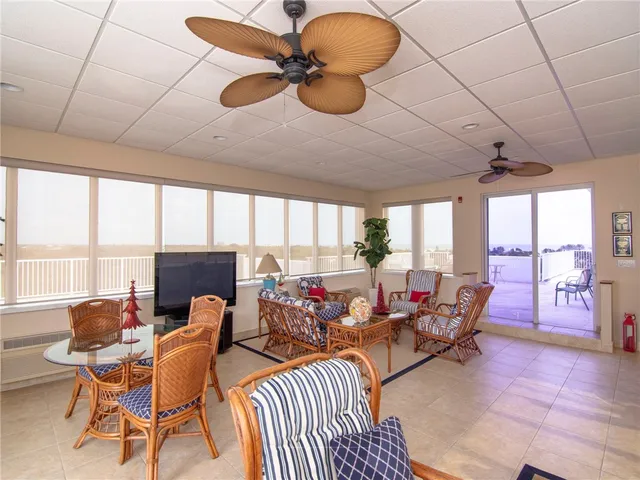 a living room with furniture a flat screen tv and a large window