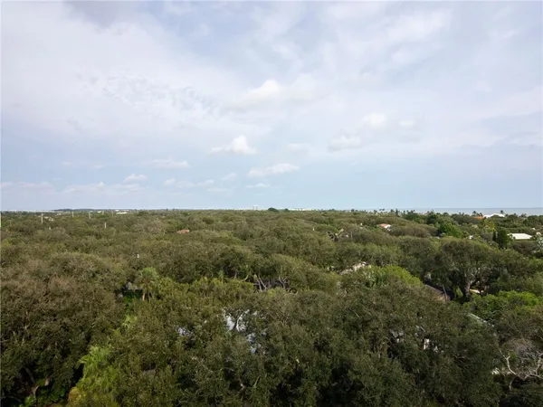 an aerial view of residential houses with outdoor space and trees