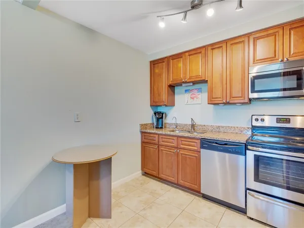 a kitchen with stainless steel appliances granite countertop a sink and a stove