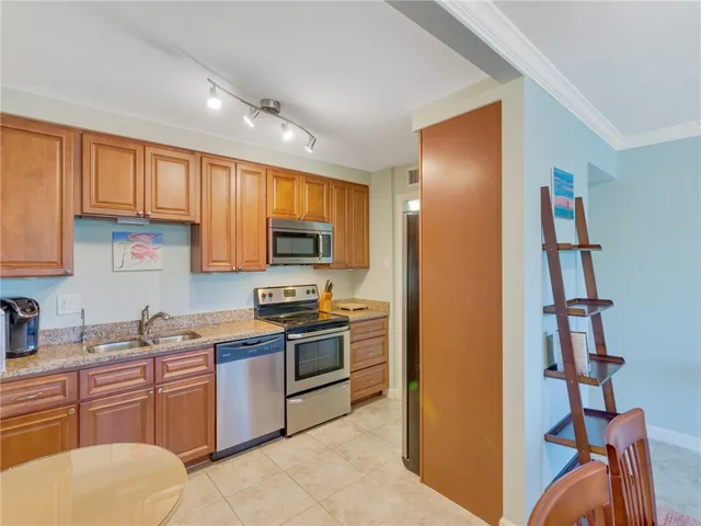 a kitchen with stainless steel appliances granite countertop a refrigerator and a stove top oven
