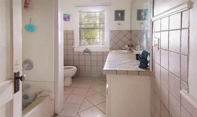a bathroom with a sink toilet and window
