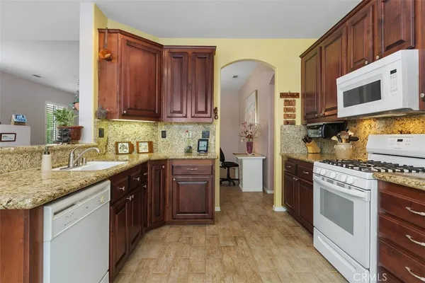 a kitchen with stainless steel appliances granite countertop a stove refrigerator sink and cabinets