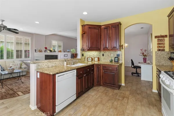 a kitchen with granite countertop a sink stove and cabinets