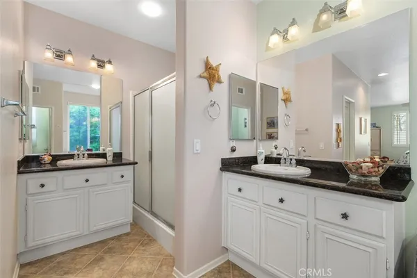a bathroom with double sink and a mirror