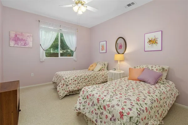 a bedroom with two beds and a chandelier