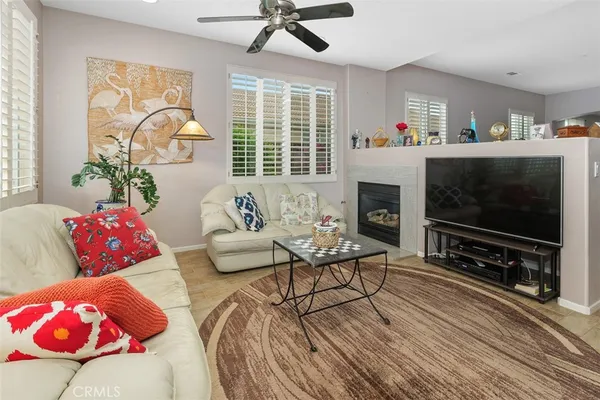 a living room with furniture a flat screen tv and a fireplace