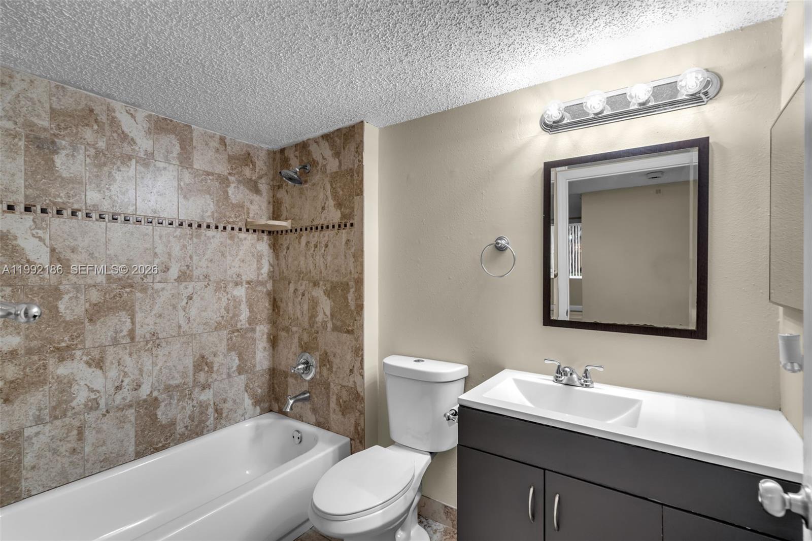 4035 West McNab Road, Unit F101 Pompano Beach, FL 33069 - Photo 13 of 25 a bathroom with a bathtub shower sink vanity mirror and toilet