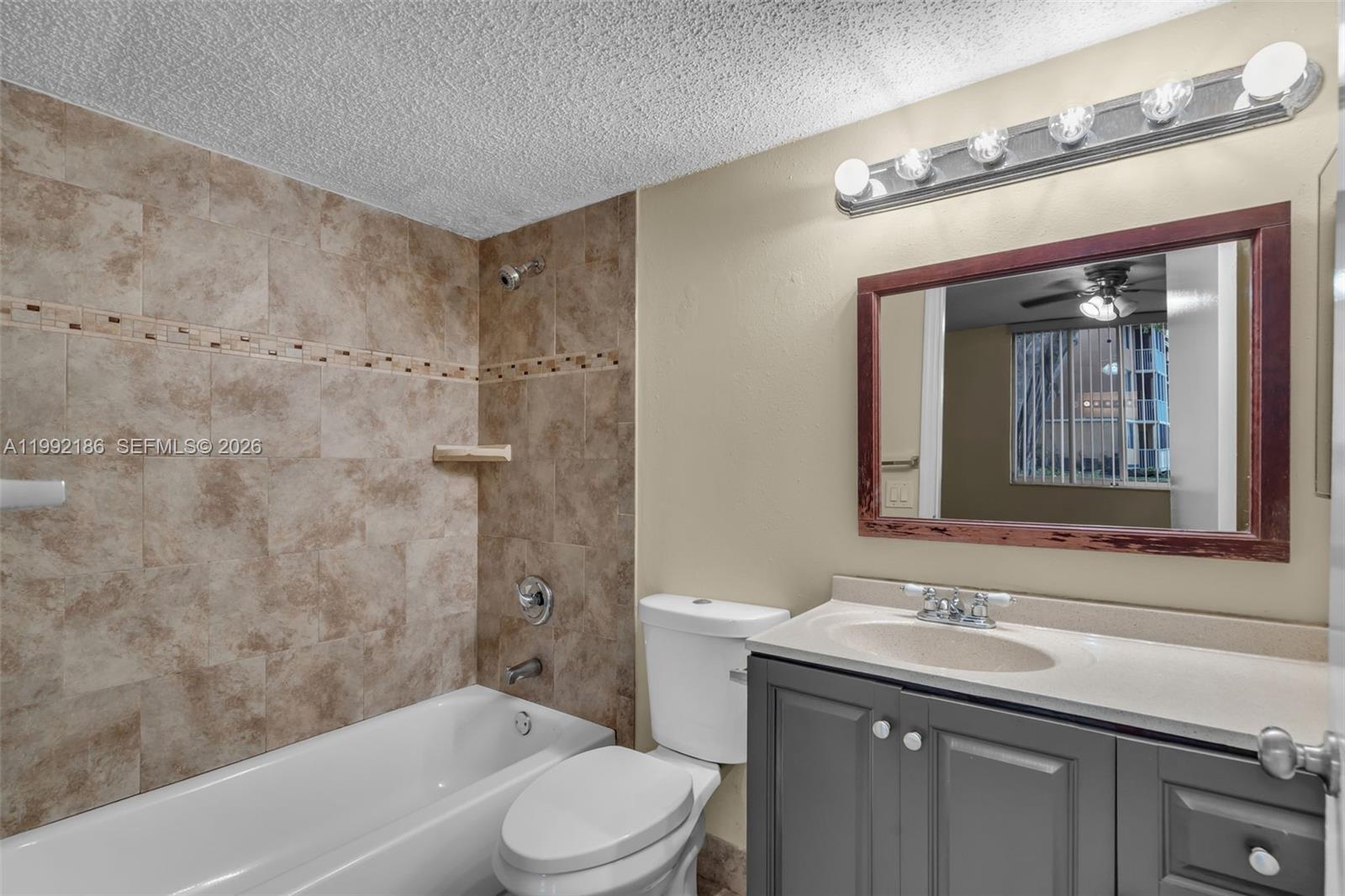 4035 West McNab Road, Unit F101 Pompano Beach, FL 33069 - Photo 14 of 25 a bathroom with a granite countertop sink toilet and shower