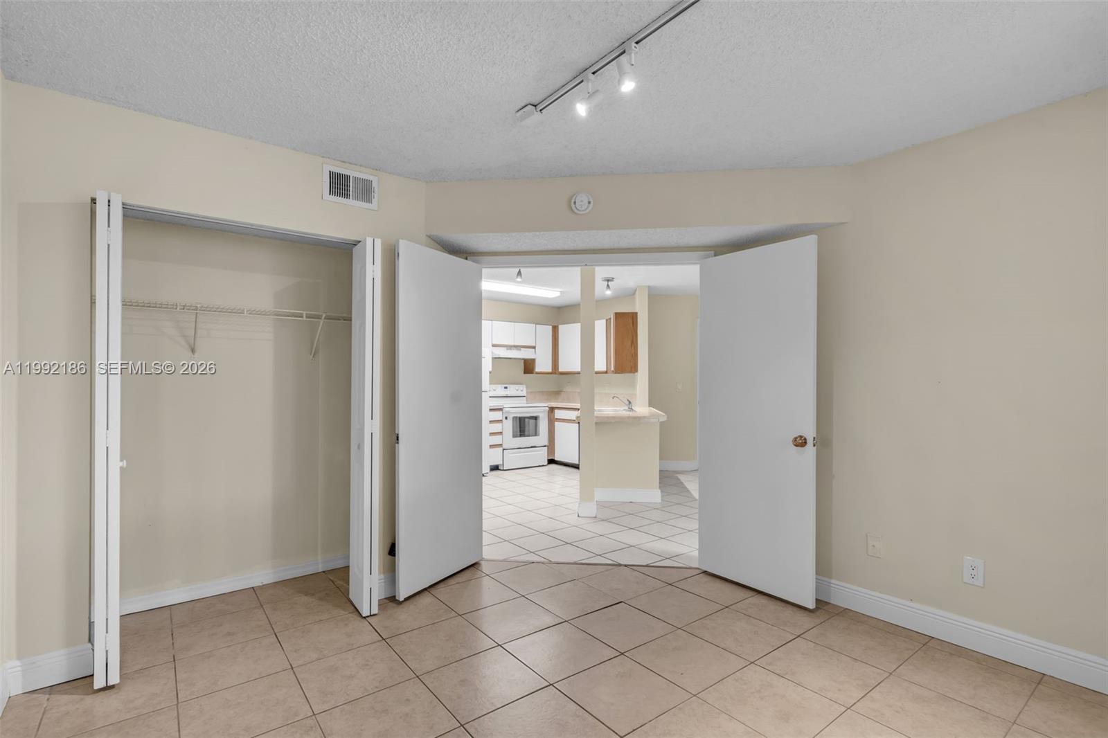 4035 West McNab Road, Unit F101 Pompano Beach, FL 33069 - Photo 16 of 25 an empty room & kitchen space with a window