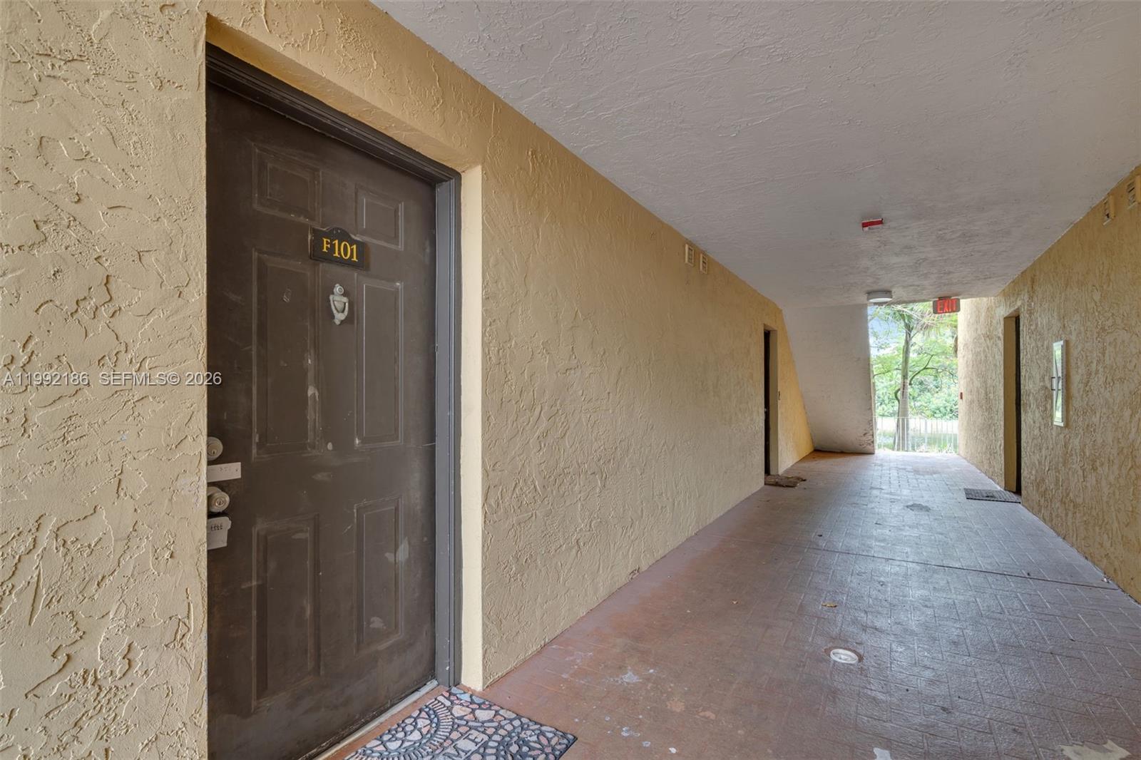 4035 West McNab Road, Unit F101 Pompano Beach, FL 33069 - Photo 2 of 25 a view of a hallway with wooden shelves