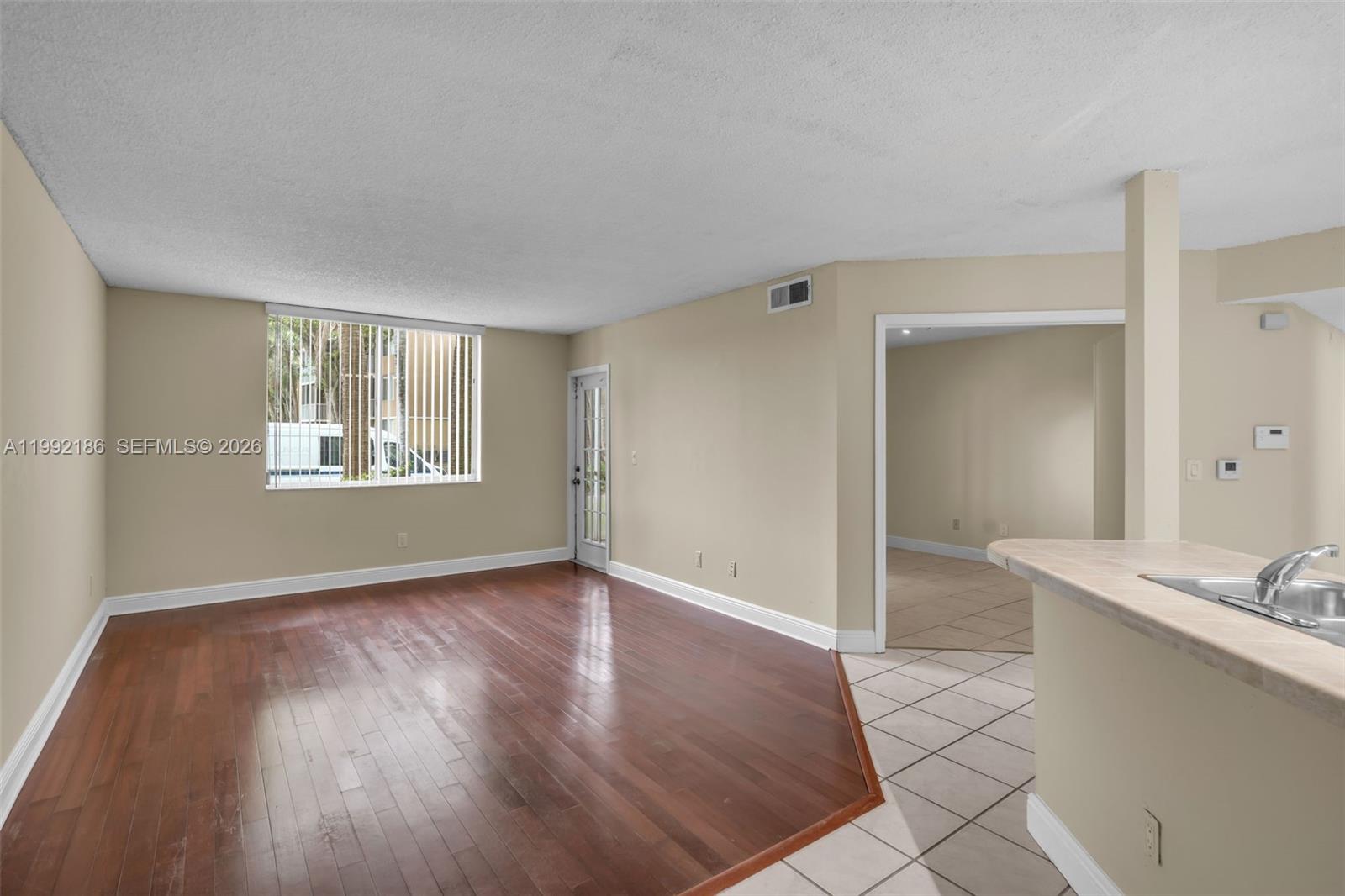 4035 West McNab Road, Unit F101 Pompano Beach, FL 33069 - Photo 3 of 25 an empty room with wooden floor and a window