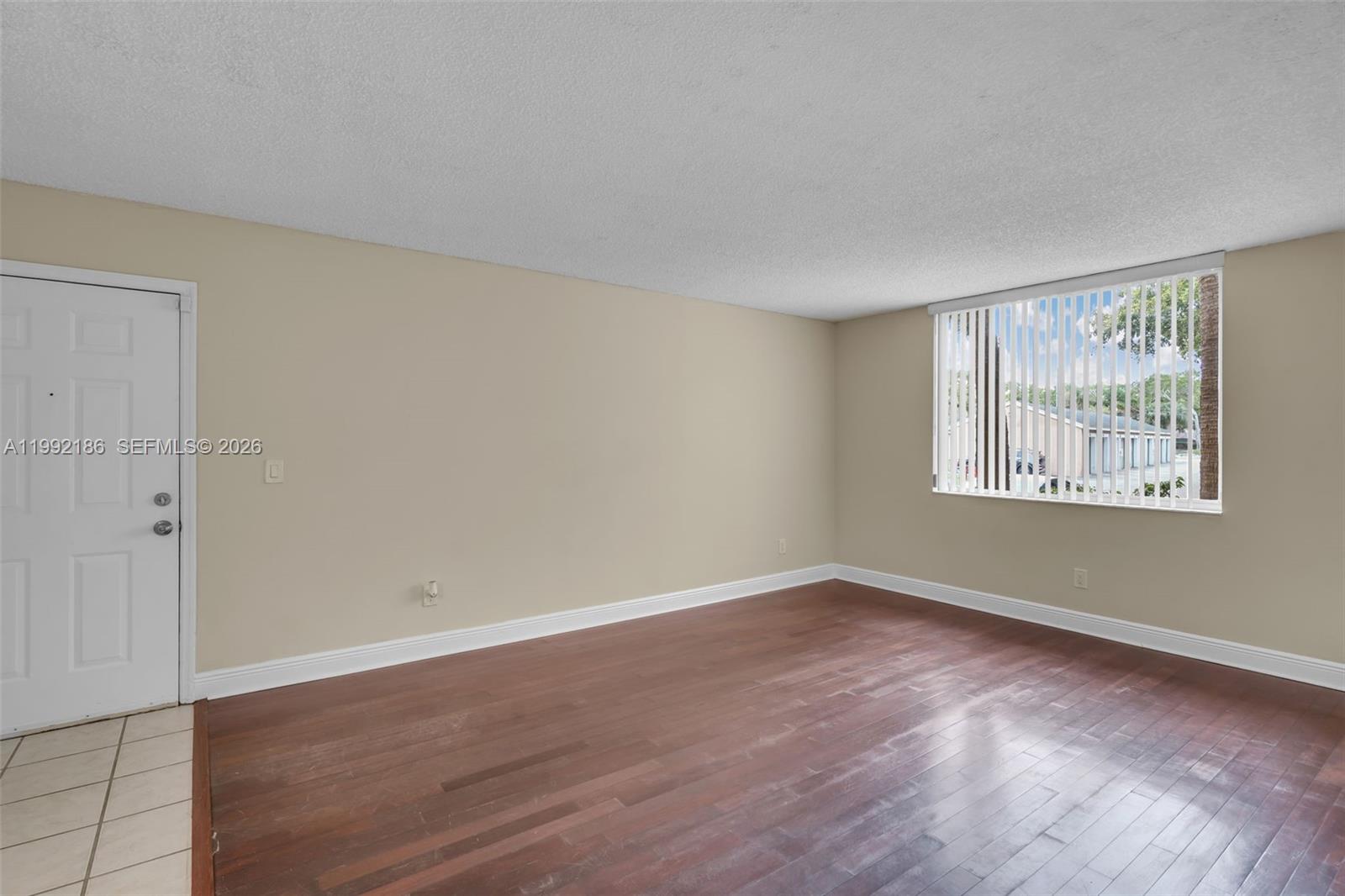 4035 West McNab Road, Unit F101 Pompano Beach, FL 33069 - Photo 4 of 25 an empty room with wooden floor and windows