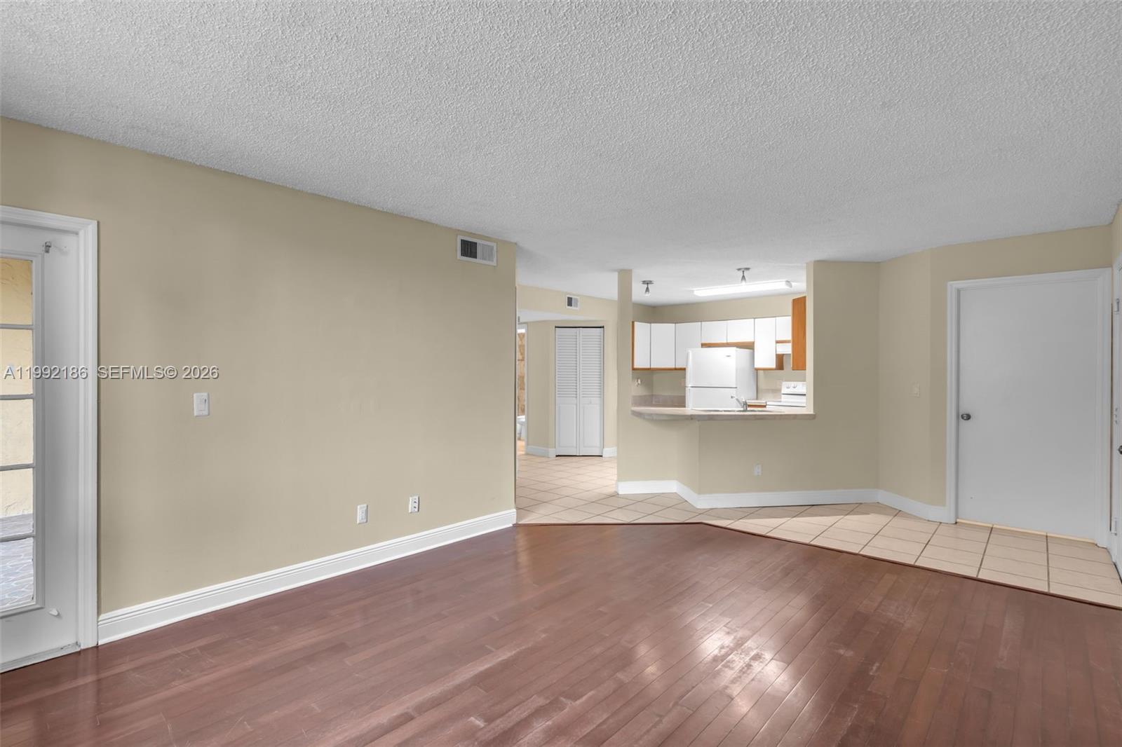 4035 West McNab Road, Unit F101 Pompano Beach, FL 33069 - Photo 6 of 25 an empty room with wooden floor & windows