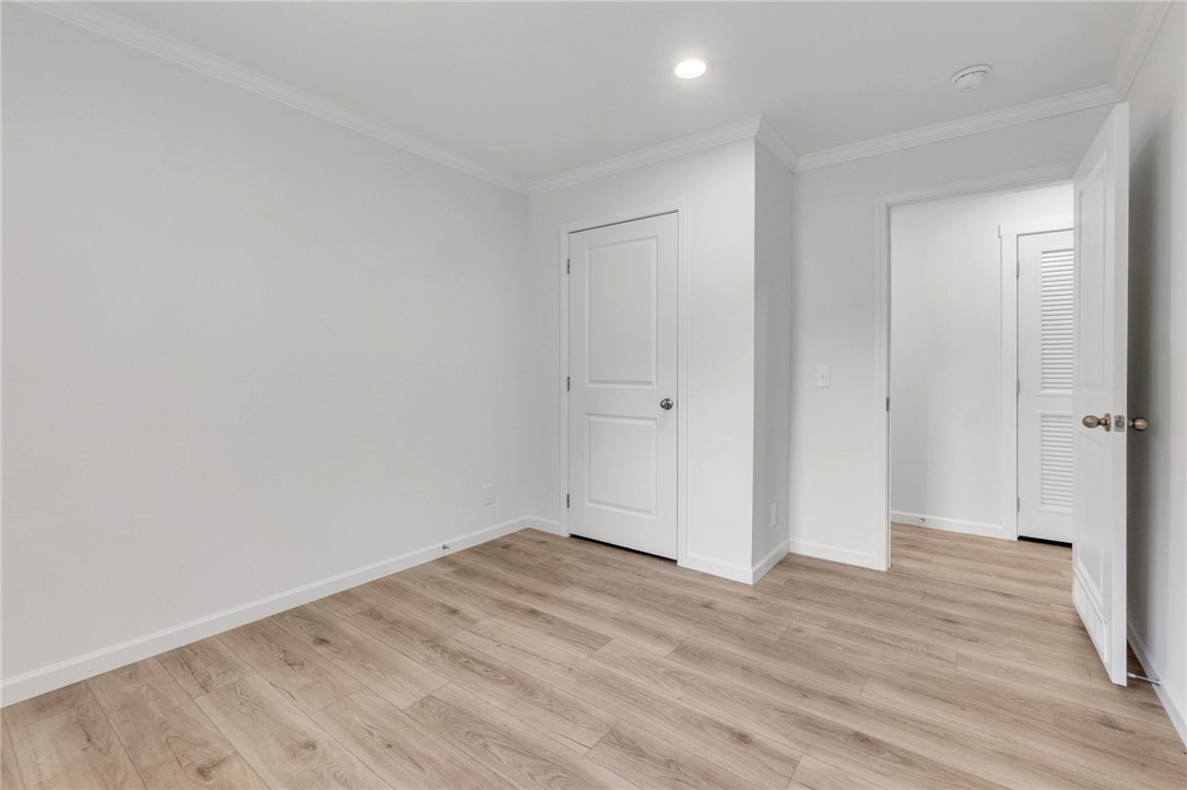 108 Old River Road Iva, SC 29655 - Photo 18 of 31 Well-lit room with wood-look flooring and crown molding, offering versatile living space.