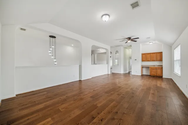a view of empty room with wooden floor and windows