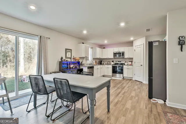 a view of kitchen with refrigerator and wooden floor