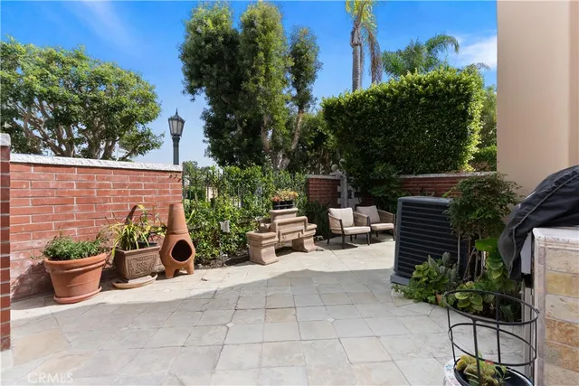 a view of a patio with table and chairs potted plants and a palm tree