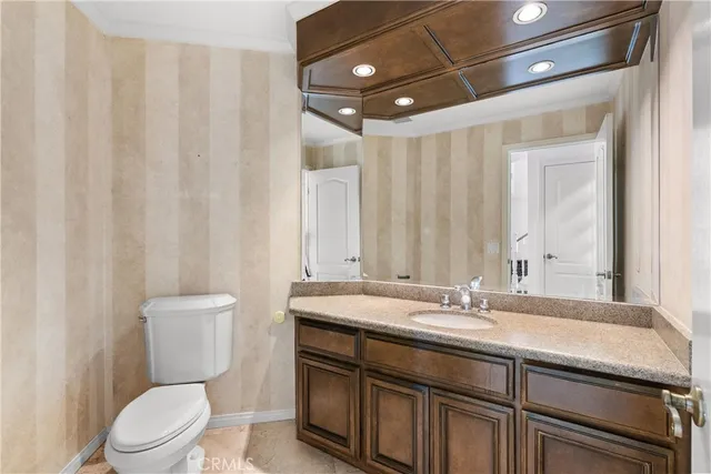 a bathroom with a granite countertop sink a toilet and a mirror